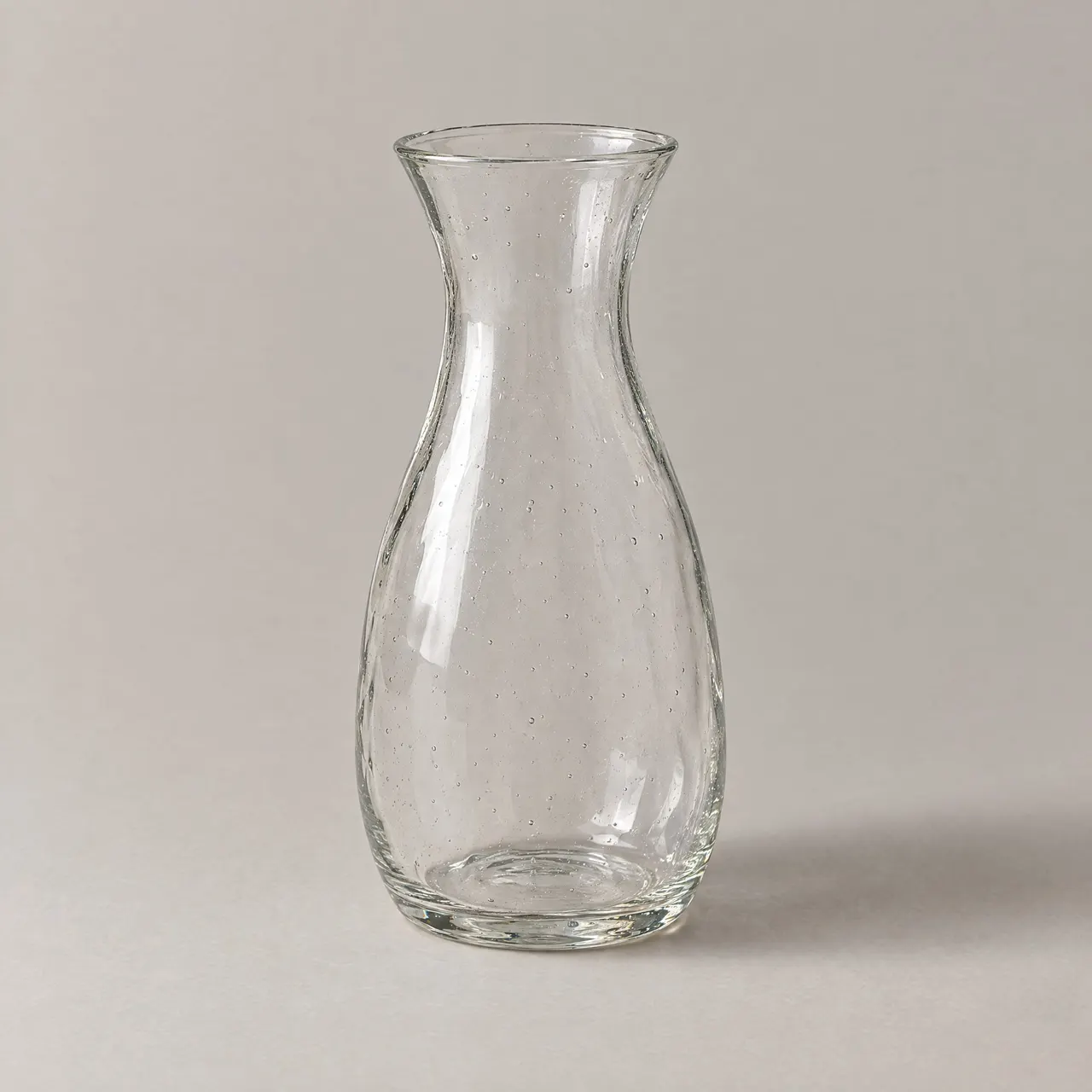 Carafe en verre soufflé transparent vue de face sur fond gris clair