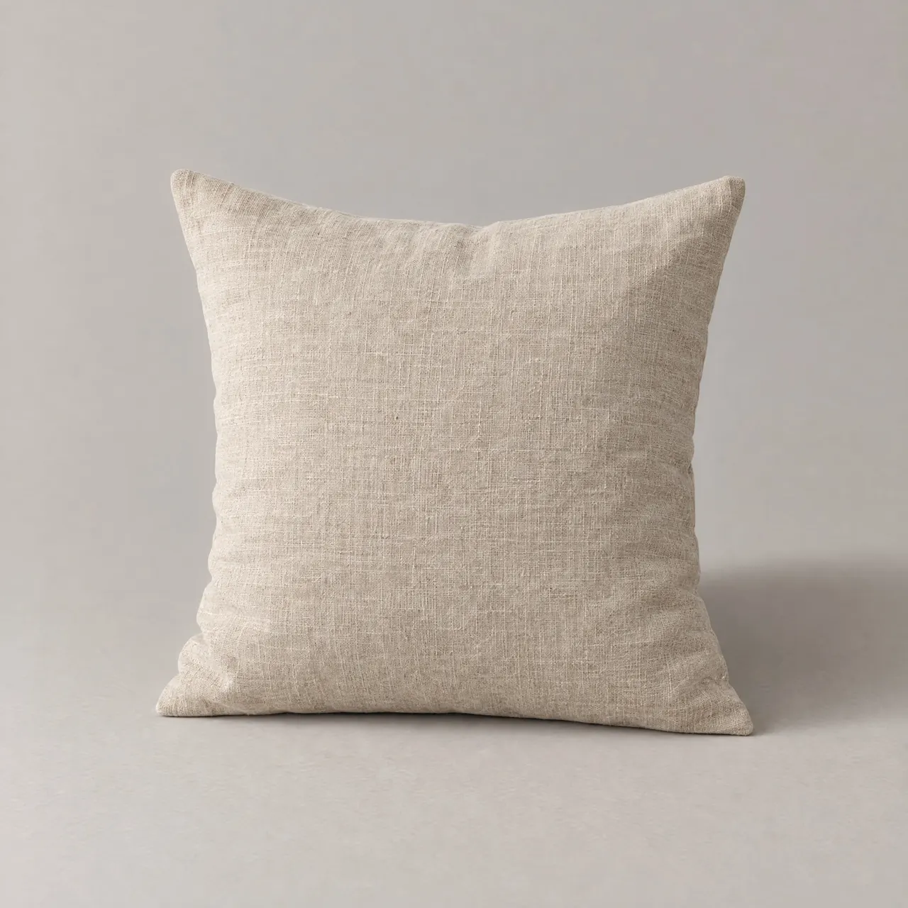 Coussin en lin lavé naturel posé debout sur fond gris clair