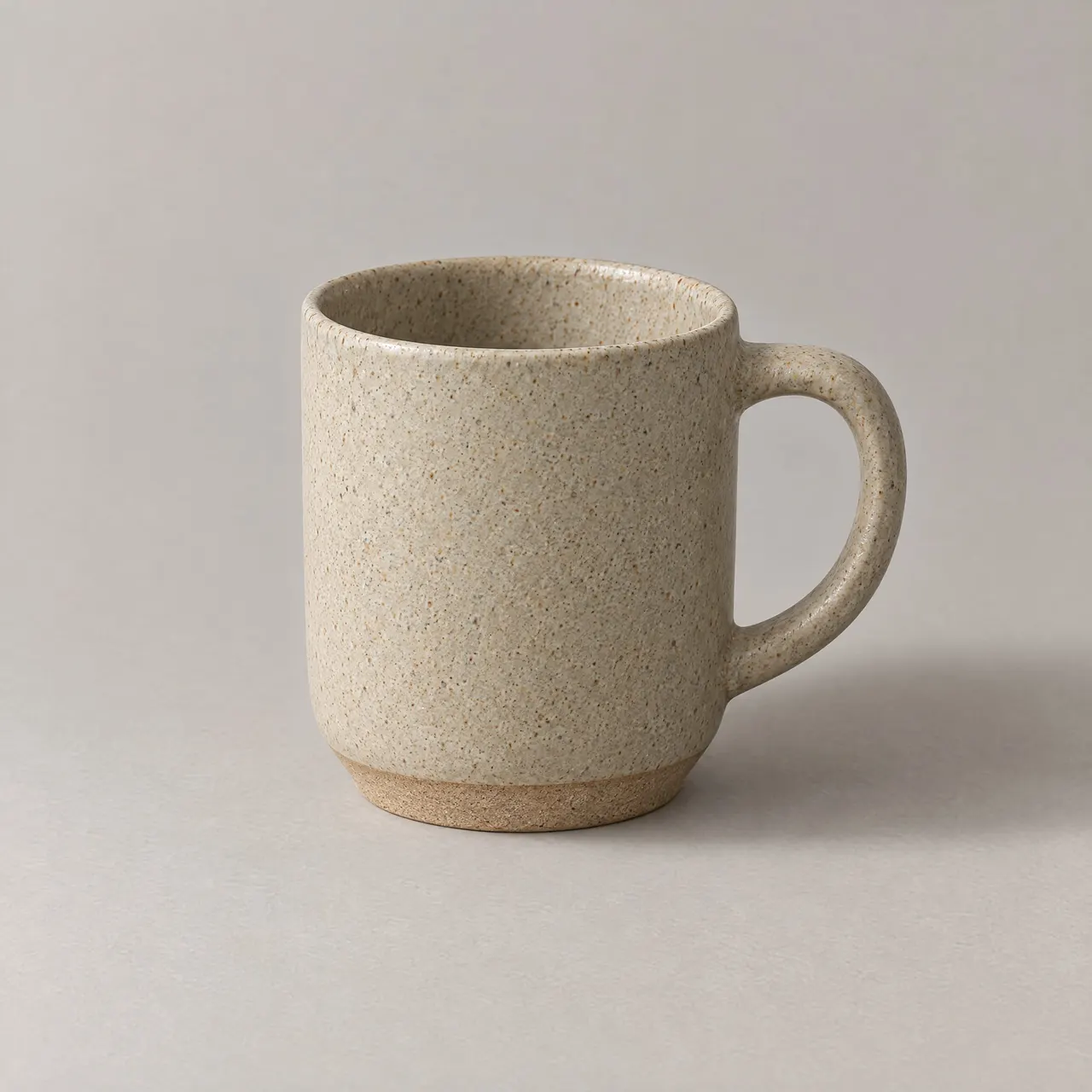 Mug en grès émaillé sable vu de trois quarts sur fond gris clair