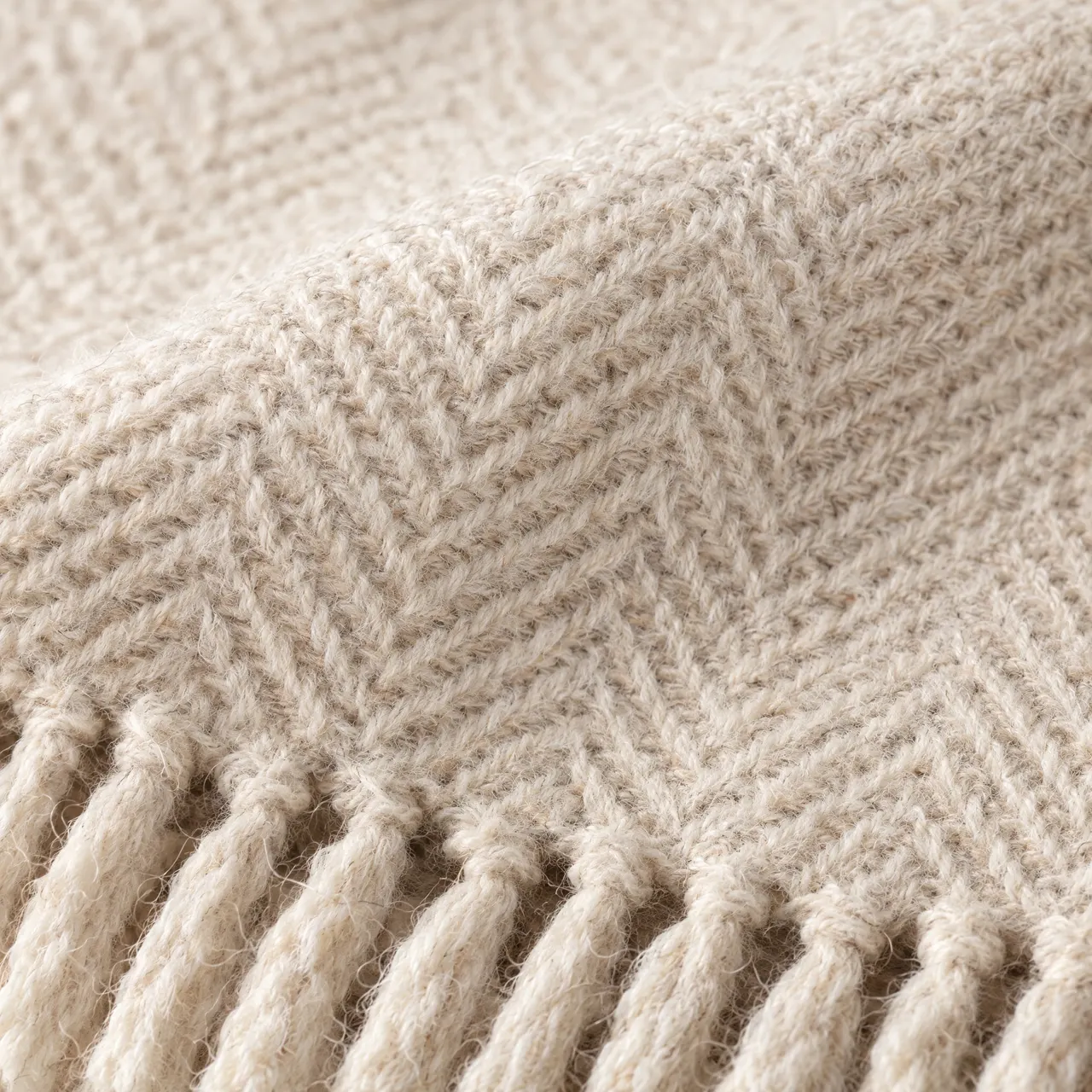 Détail du tissage à chevrons de la laine écrue et des franges torsadées