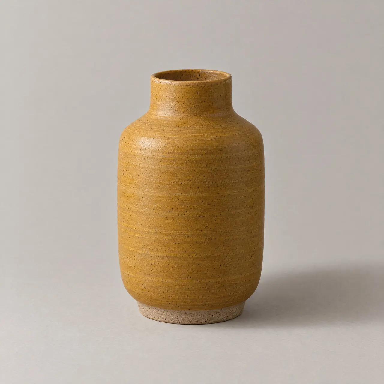 Vase en grès émaillé ocre mat à col étroit, vu de face sur fond gris clair