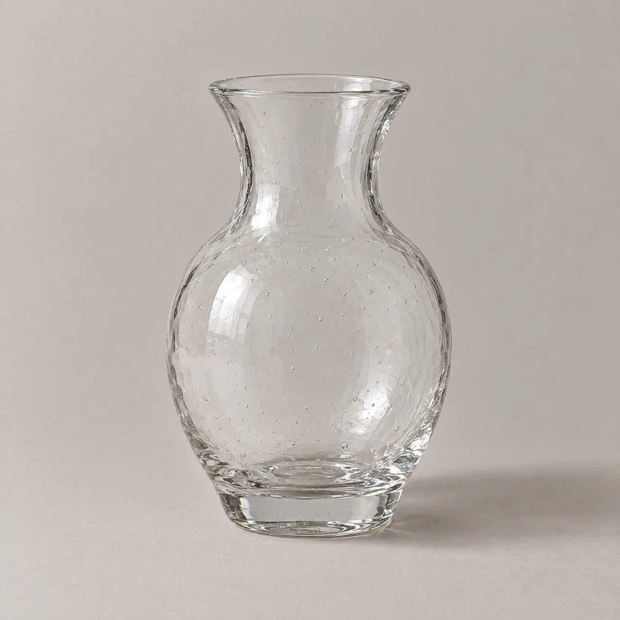 Vase en verre soufflé transparent à panse large vu de face sur fond gris clair